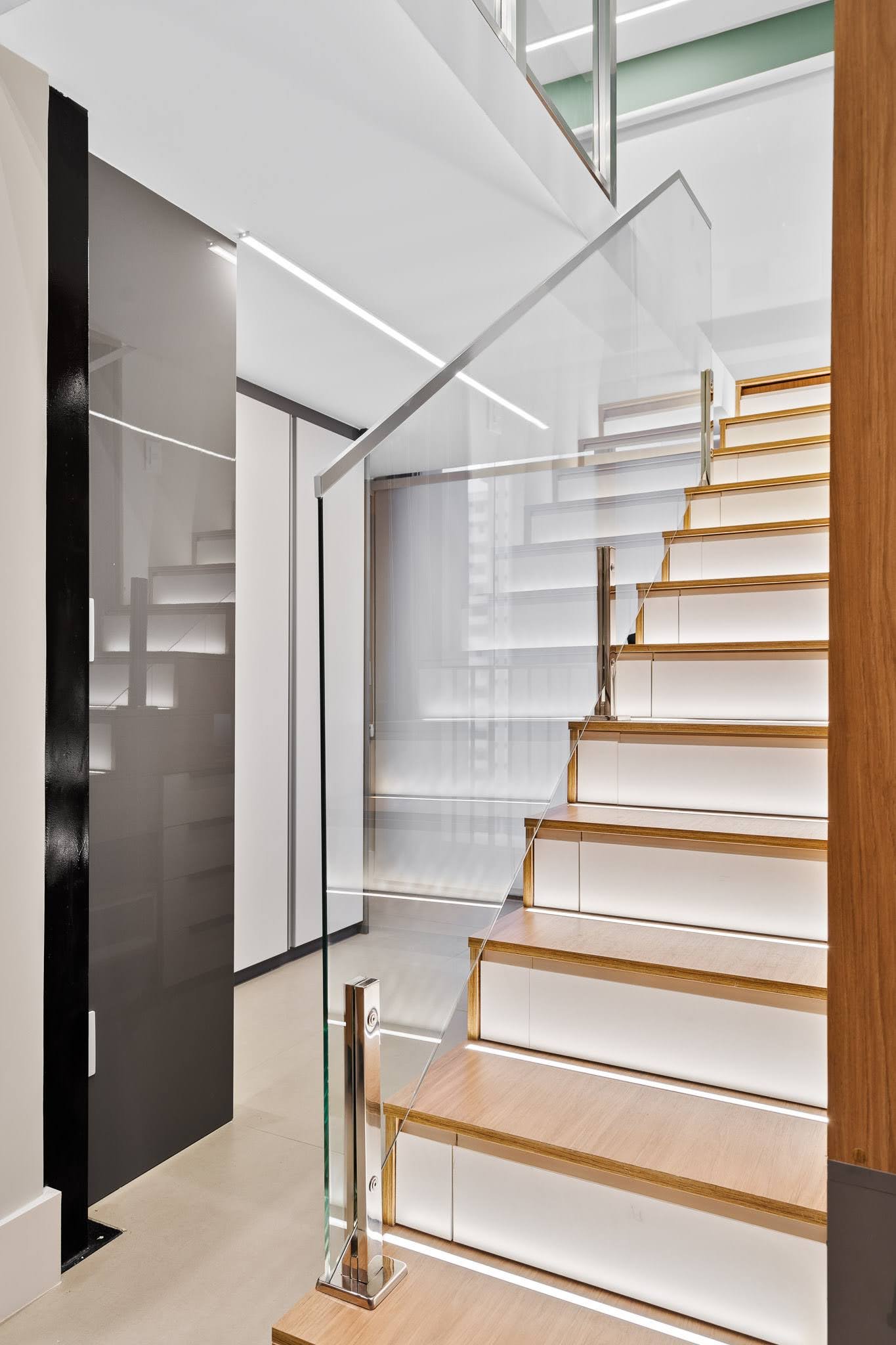 This staircase, fitted with drawer fronts and recessed lighting, functions as both circulation and storage.