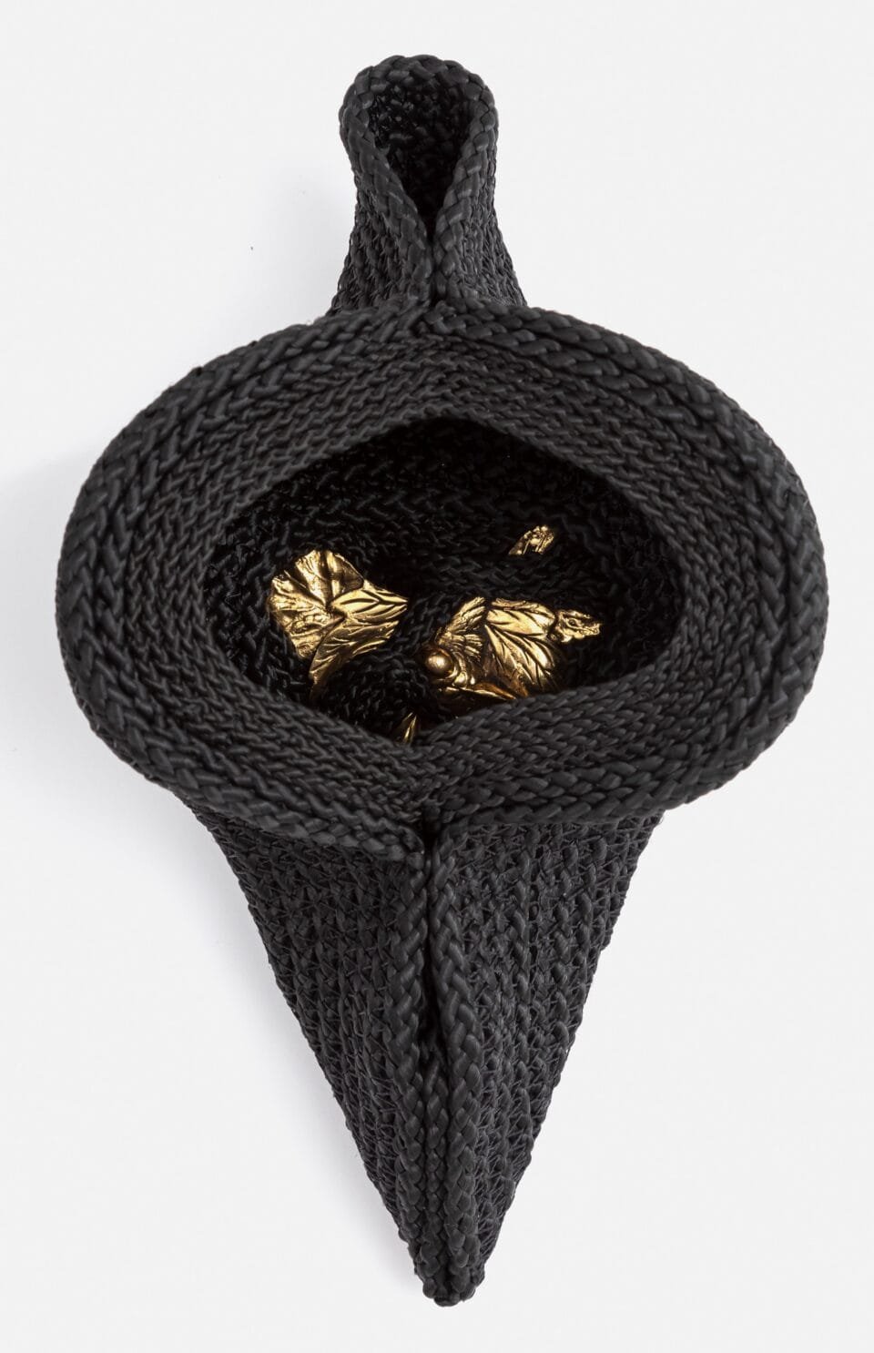 an artwork made from black cord, thread, and metal with a hole in the center with a shiny object in it