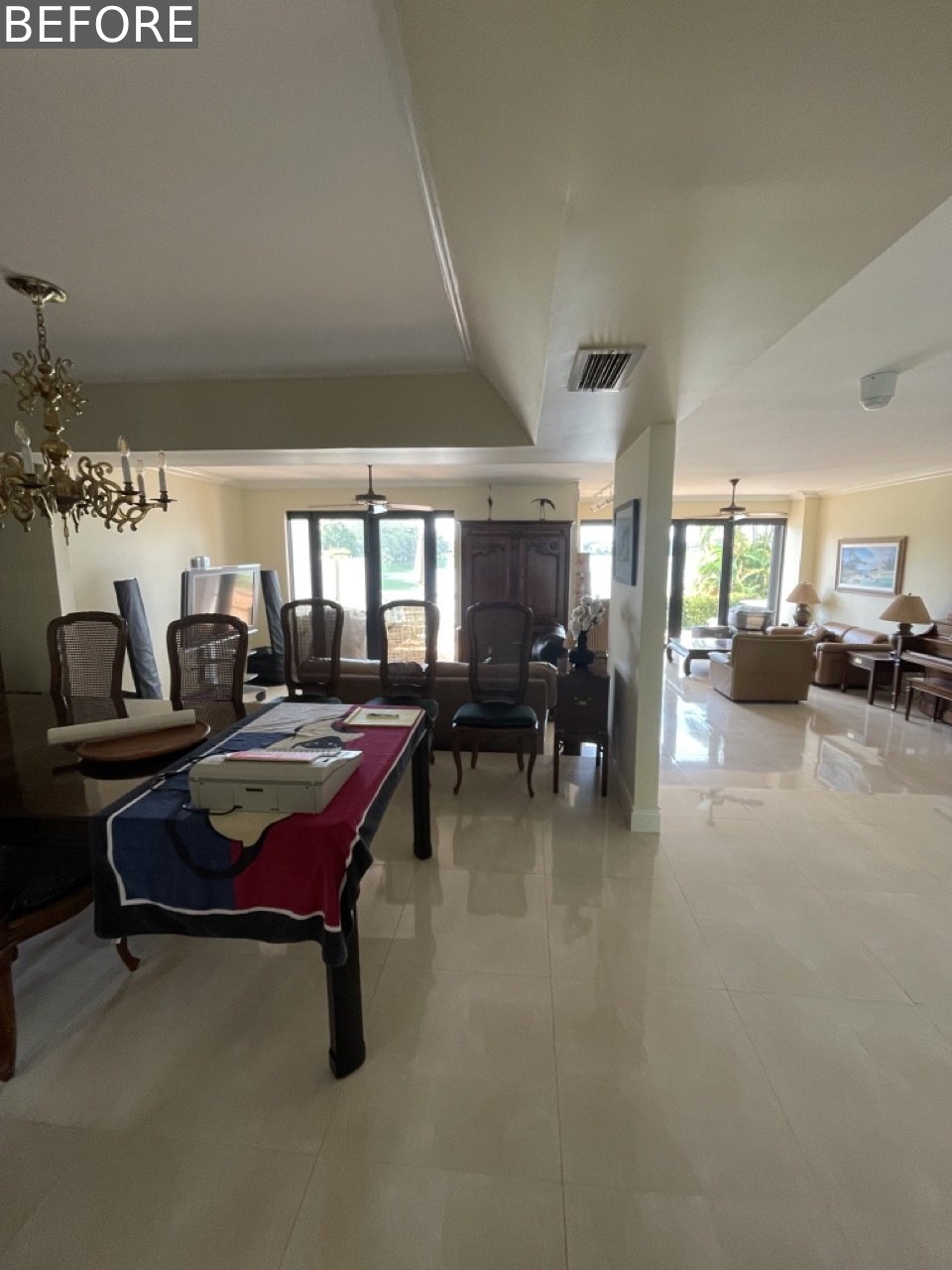 BEFORE - The original dining room was dominated by a large, oversized table and dark, bulky furniture. A full mirrored wall reflected an ornate chandelier overhead, giving the space a formal, almost imposing feel.