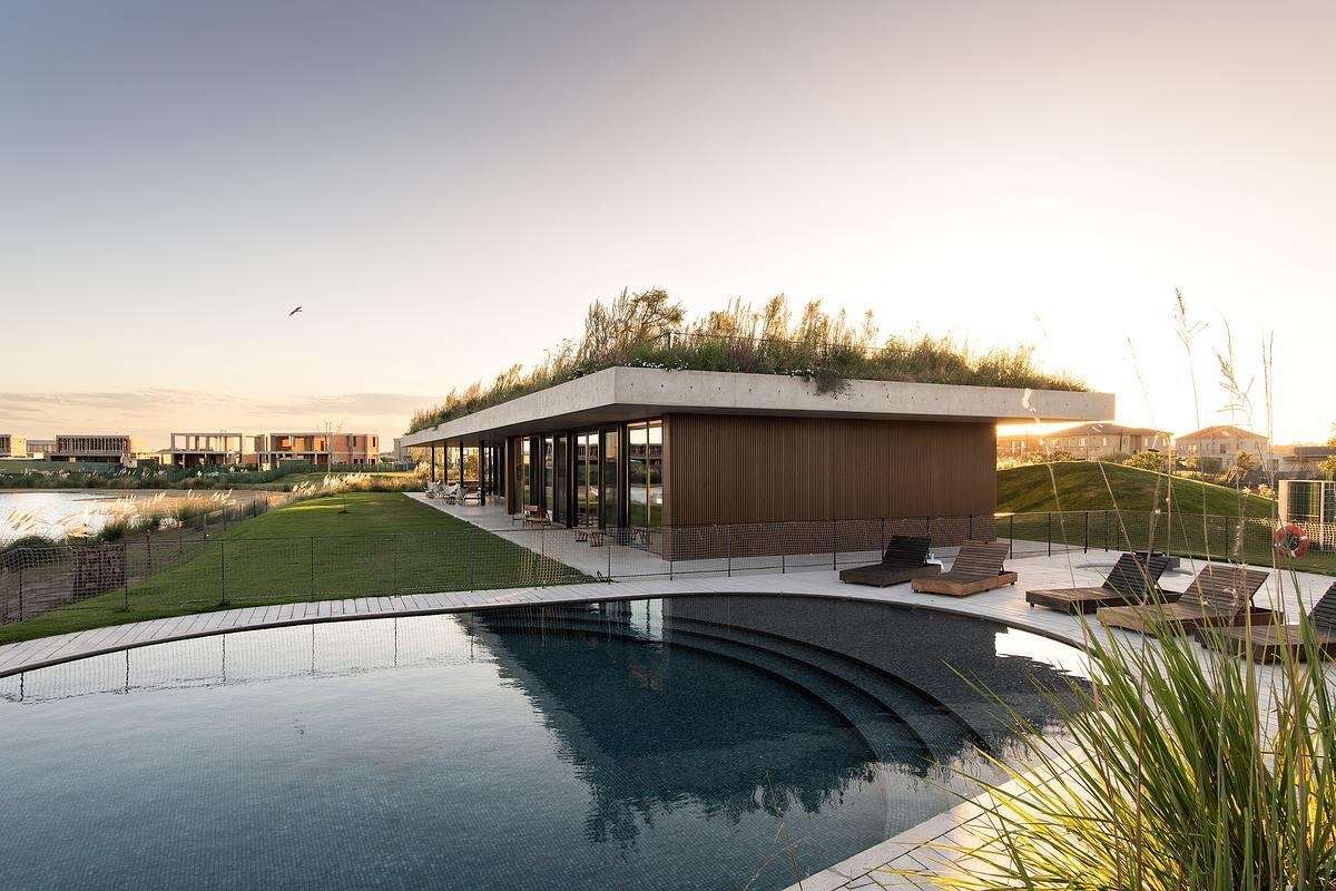 Tucked just beside this clubhouse with a green roof, the swimming pool feels like a natural extension of the lake beyond. It’s positioned to capture long views across the water while still feeling sheltered and grounded by the surrounding architecture and landscape. The design avoids excess, no flashy features or oversized decking, just clean lines, calm water, and a subtle integration with the terrain.