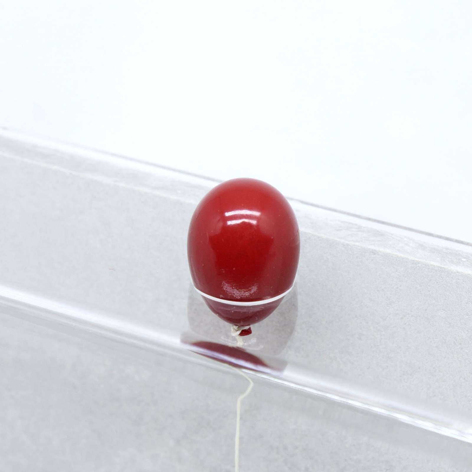 a detail of a sculptural red balloon that peeks out of the frame