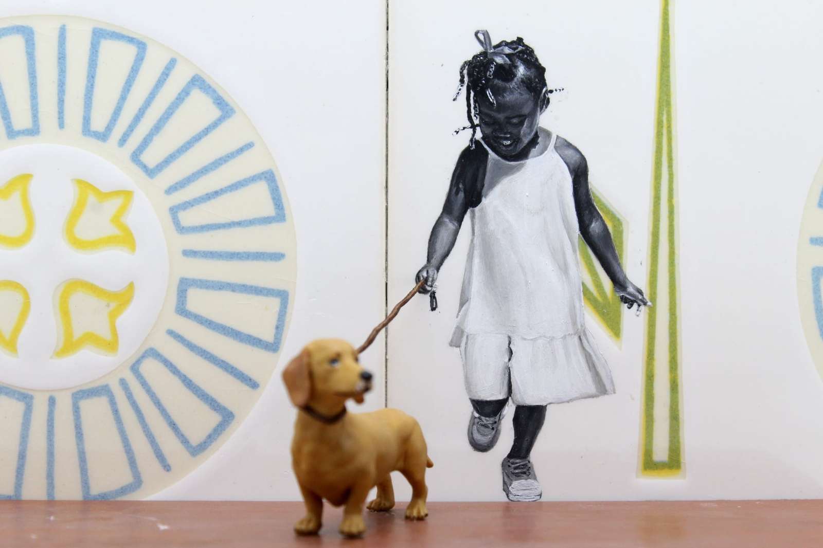 a detail of a painting of a child on a tile walking a sculpture of a dog