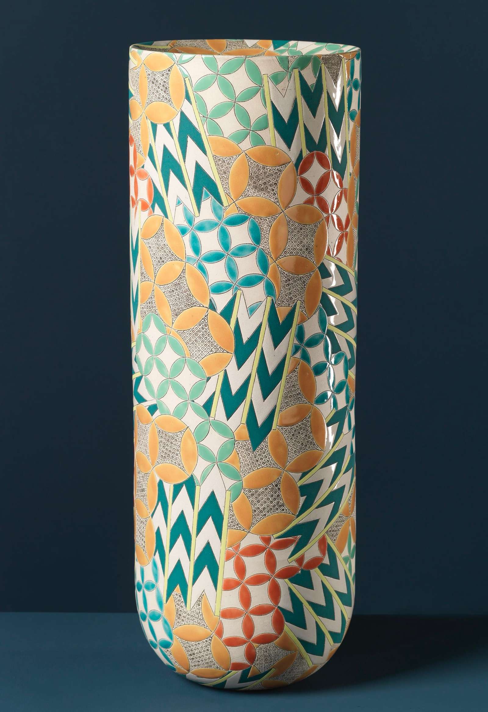 a colorful, geometrically patterned, cylindrical ceramic form