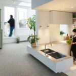 A sunken kitchen tucked into the central tower adds depth and separation without walls, maximizing both space and light in this compact family home.