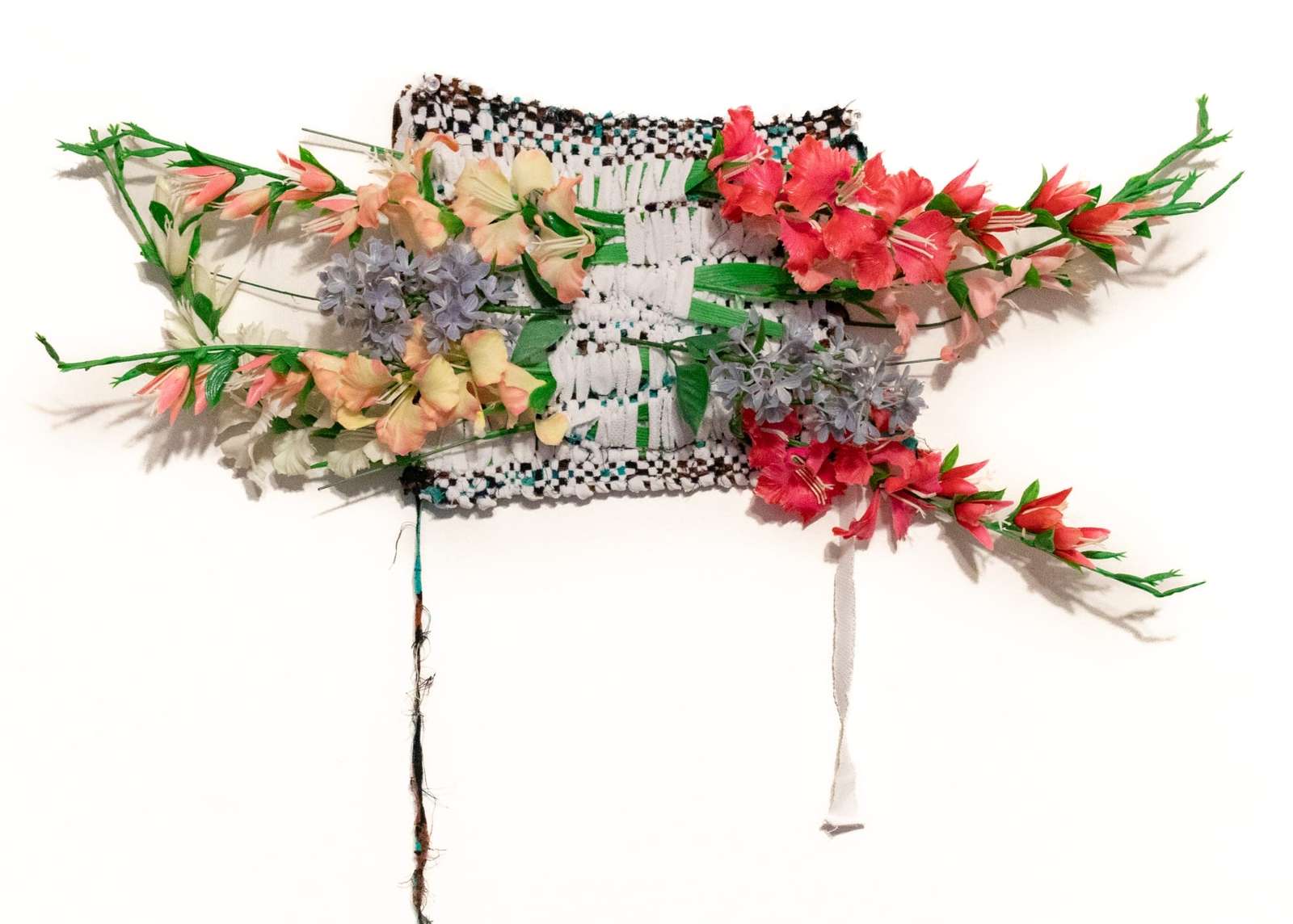 a weaving with synthetic flowers