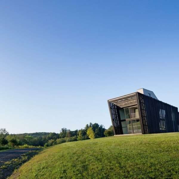 Wrapped in charred timber and set on a concrete base, this sculptural hillside home stands as a minimalist landmark in New York’s Hudson Valley.