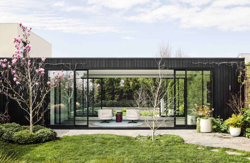 This Melbourne residence combines a restored Victorian facade with dark timber and glass for a seamless modern contrast.