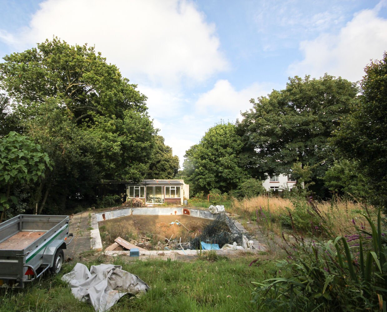 Before the build, this overgrown Guernsey site was a forgotten corner surrounded by trees. The Before section shows how DLM Architects began transforming it into a calm, contemporary family home rooted in nature.