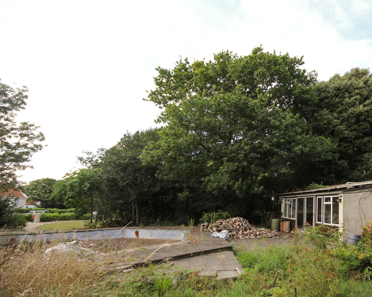 Before the build, this overgrown Guernsey site was a forgotten corner surrounded by trees. The Before section shows how DLM Architects began transforming it into a calm, contemporary family home rooted in nature.