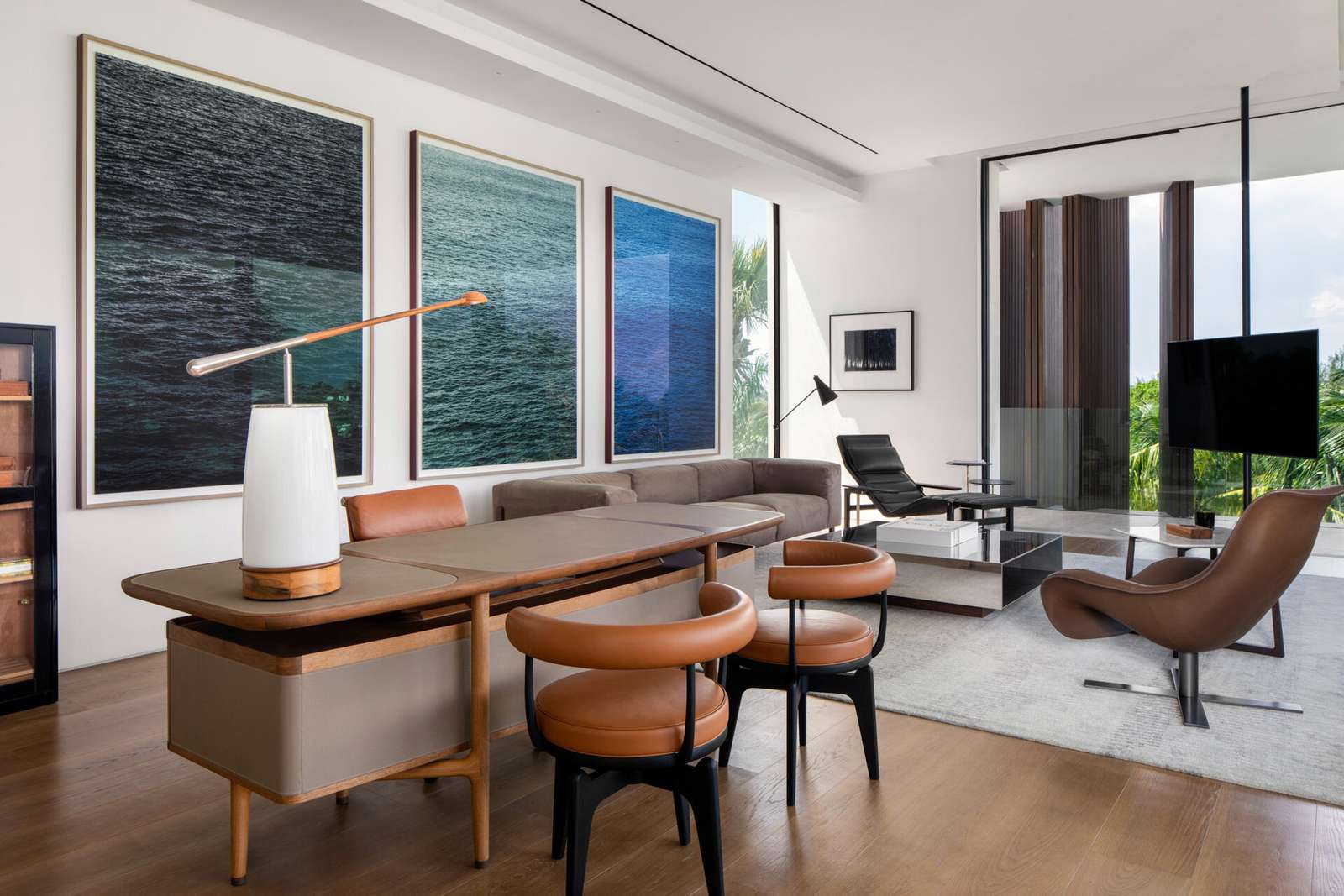Interiors, like this home office, are filled with timber, stone, and local artwork create a warm contrast to the clean architecture.