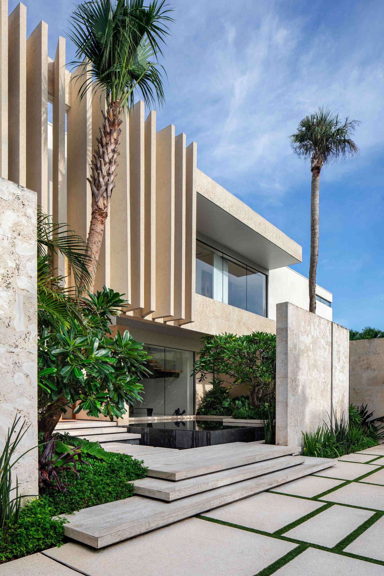 A modern island home shaped by coral stone fins and generous glazing that opens to the landscape.