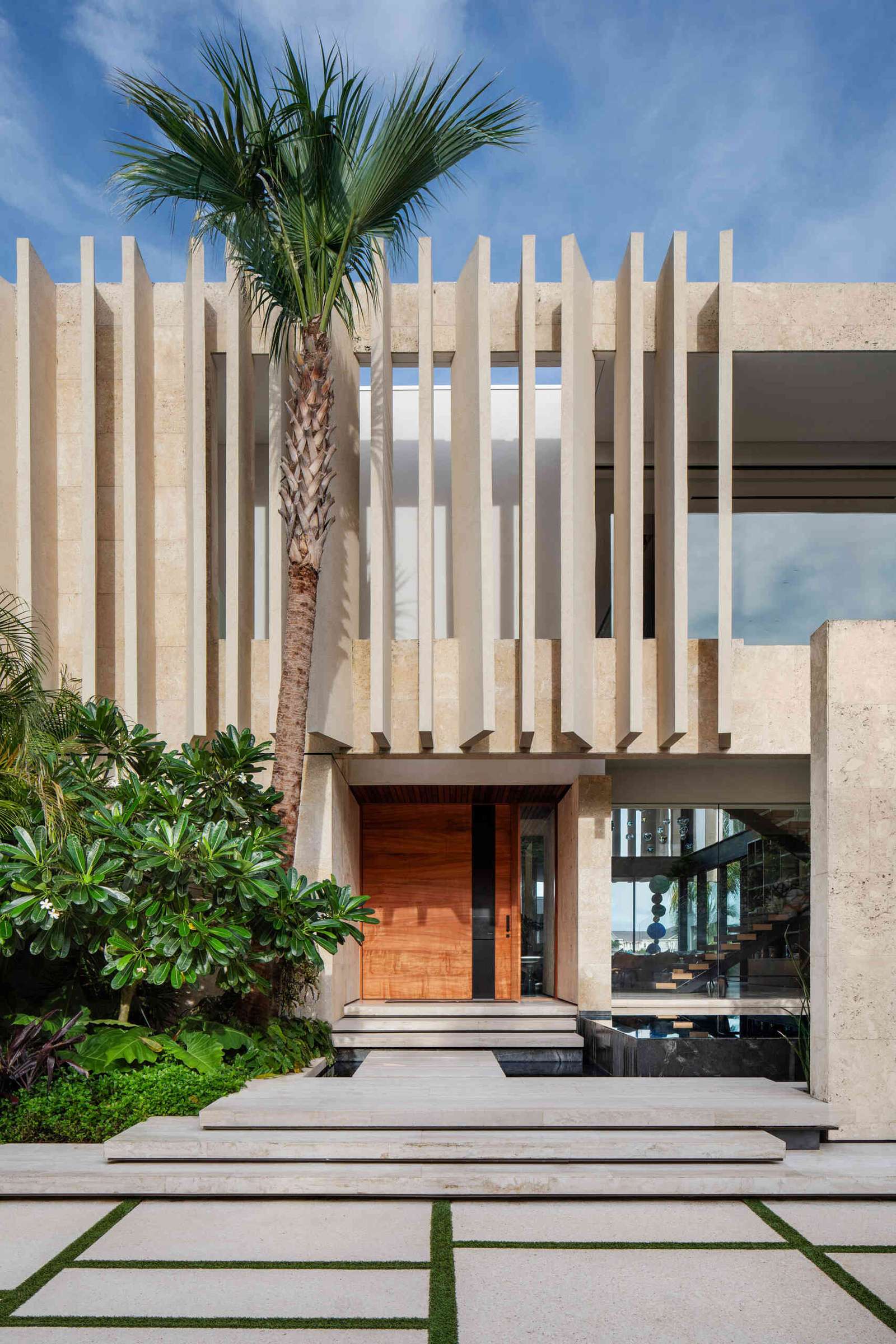 A modern island home shaped by coral stone fins and generous glazing that opens to the landscape.