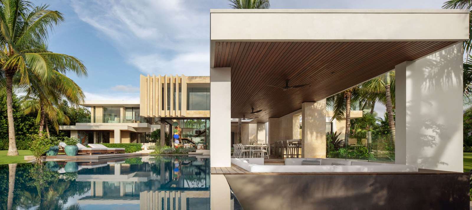 A tropical home with outdoor rooms and an infinity pool that blends naturally with the canal and surrounding greenery.