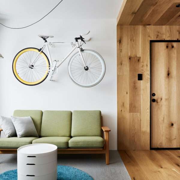 A built-in window seat and soft woven flooring add warmth and storage to the living room of this cleverly designed small apartment.