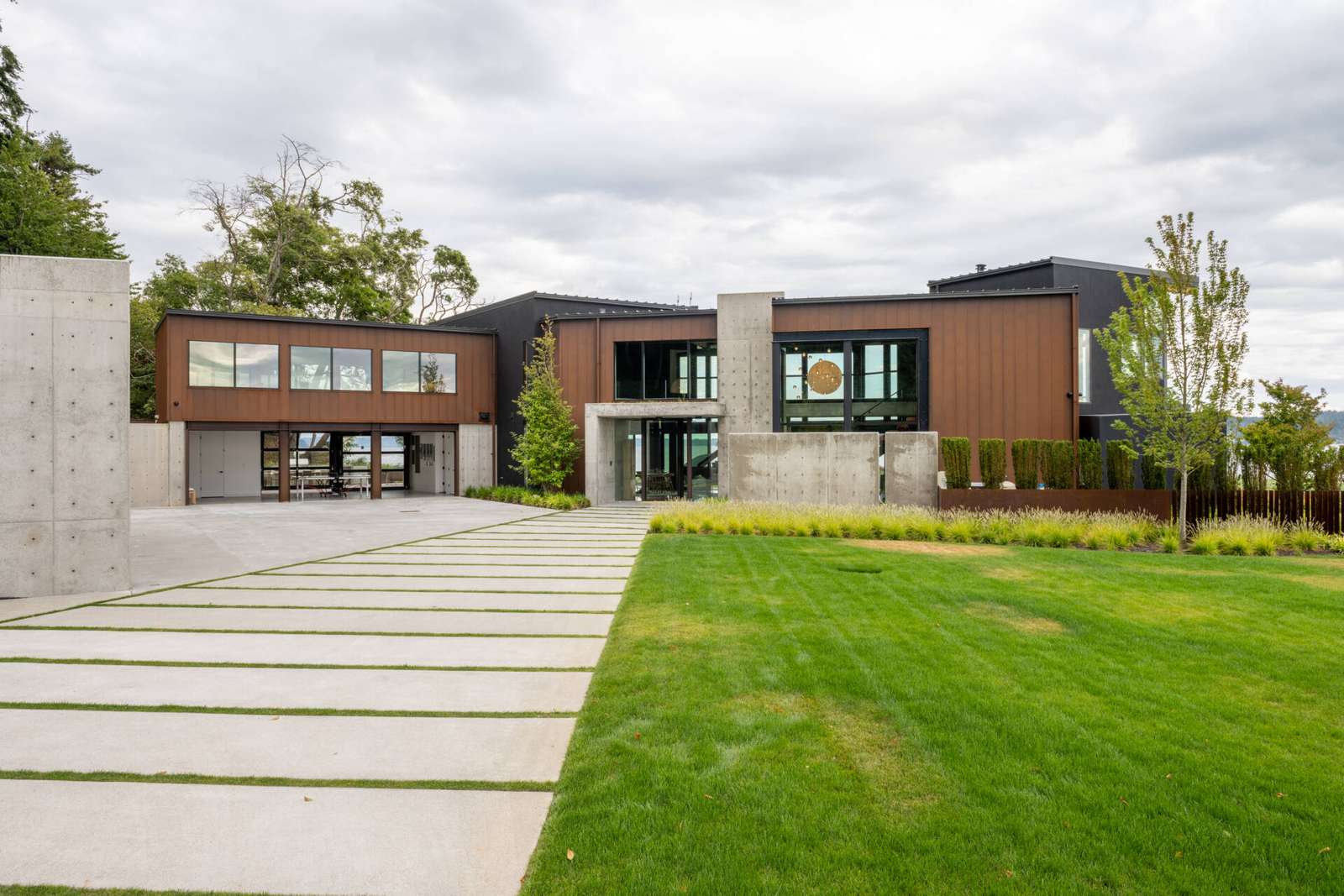 A steep hillside behind the home shaped how access and structure were planned. The driveway and garage zones are engineered as protective elements rather than simple arrival points.