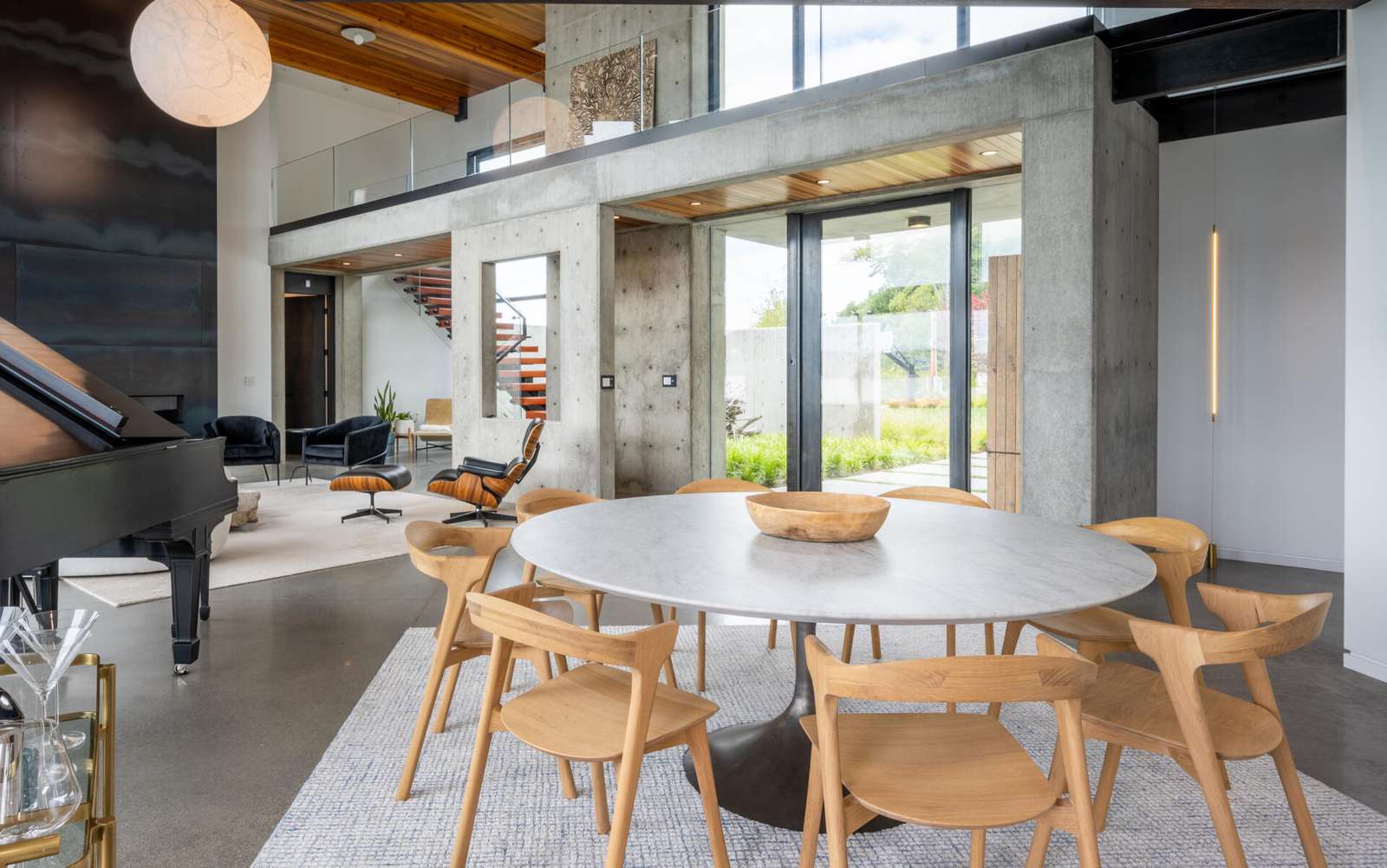 The dining area, with its round table, is integrated into the open great room between the living room and the kitchen.