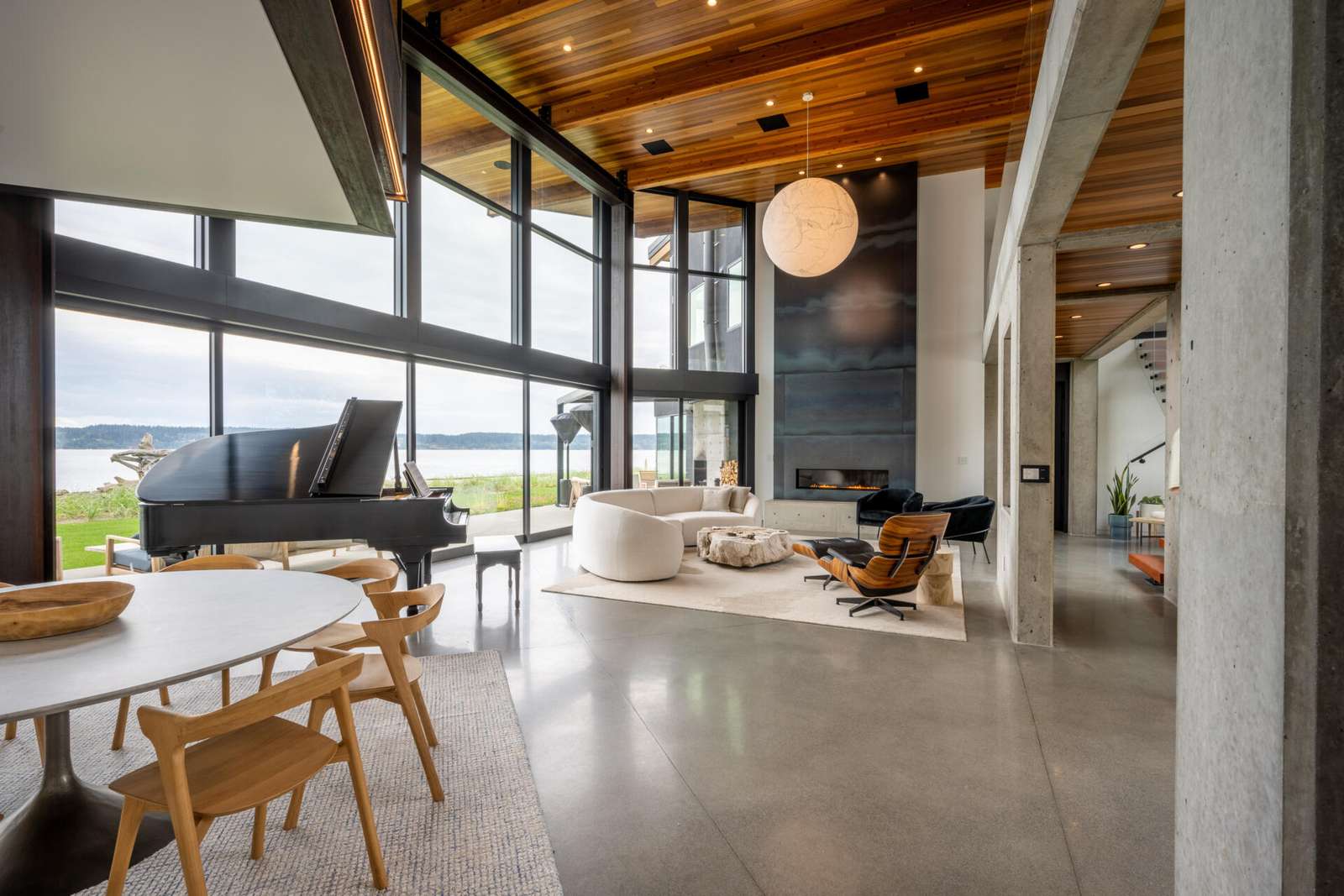 The great room acts as the heart of the house, linking two wings while opening fully to the water. Large sliding glass walls allow daily life to flow outdoors.