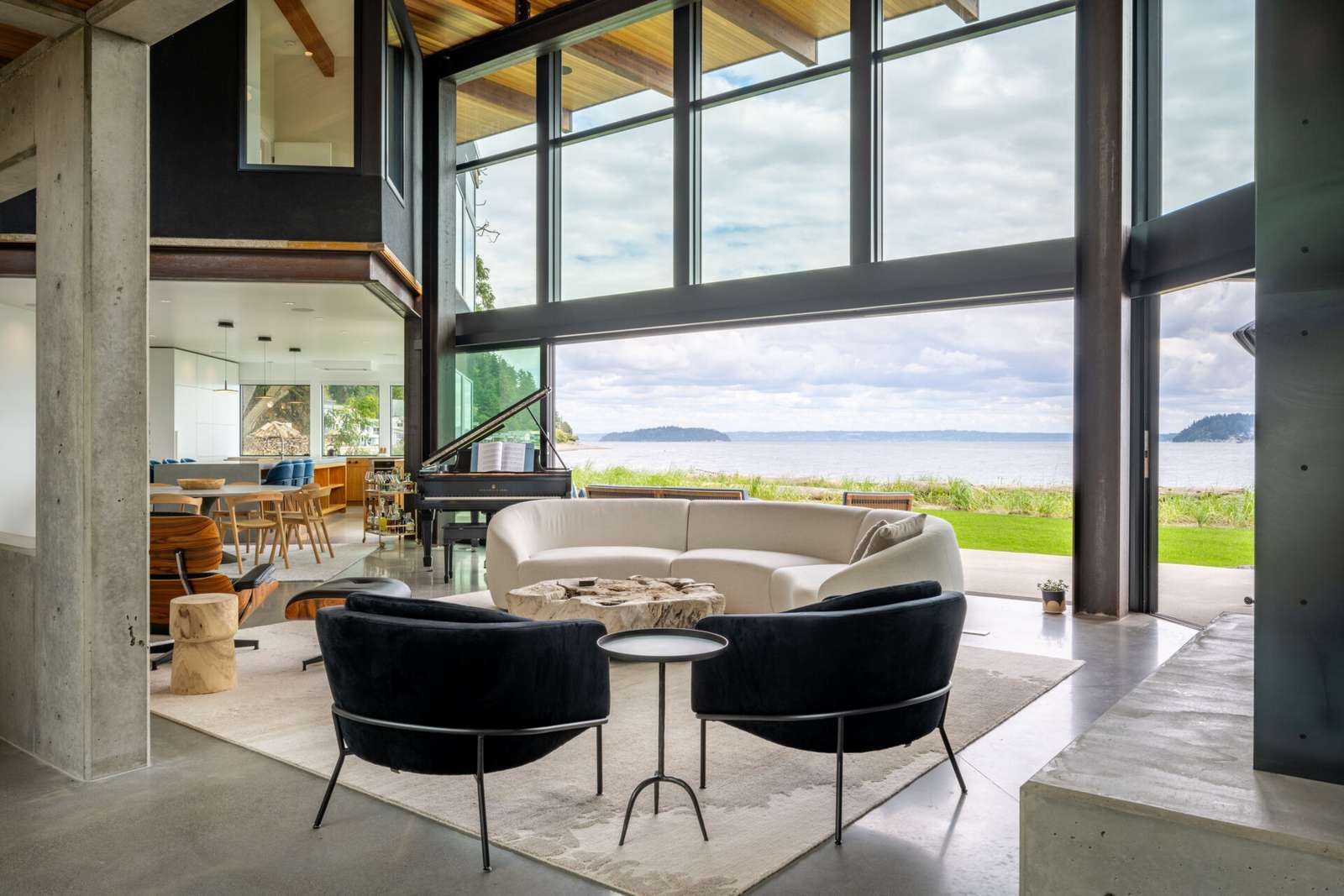 The great room acts as the heart of the house, linking two wings while opening fully to the water. Large sliding glass walls allow daily life to flow outdoors.
