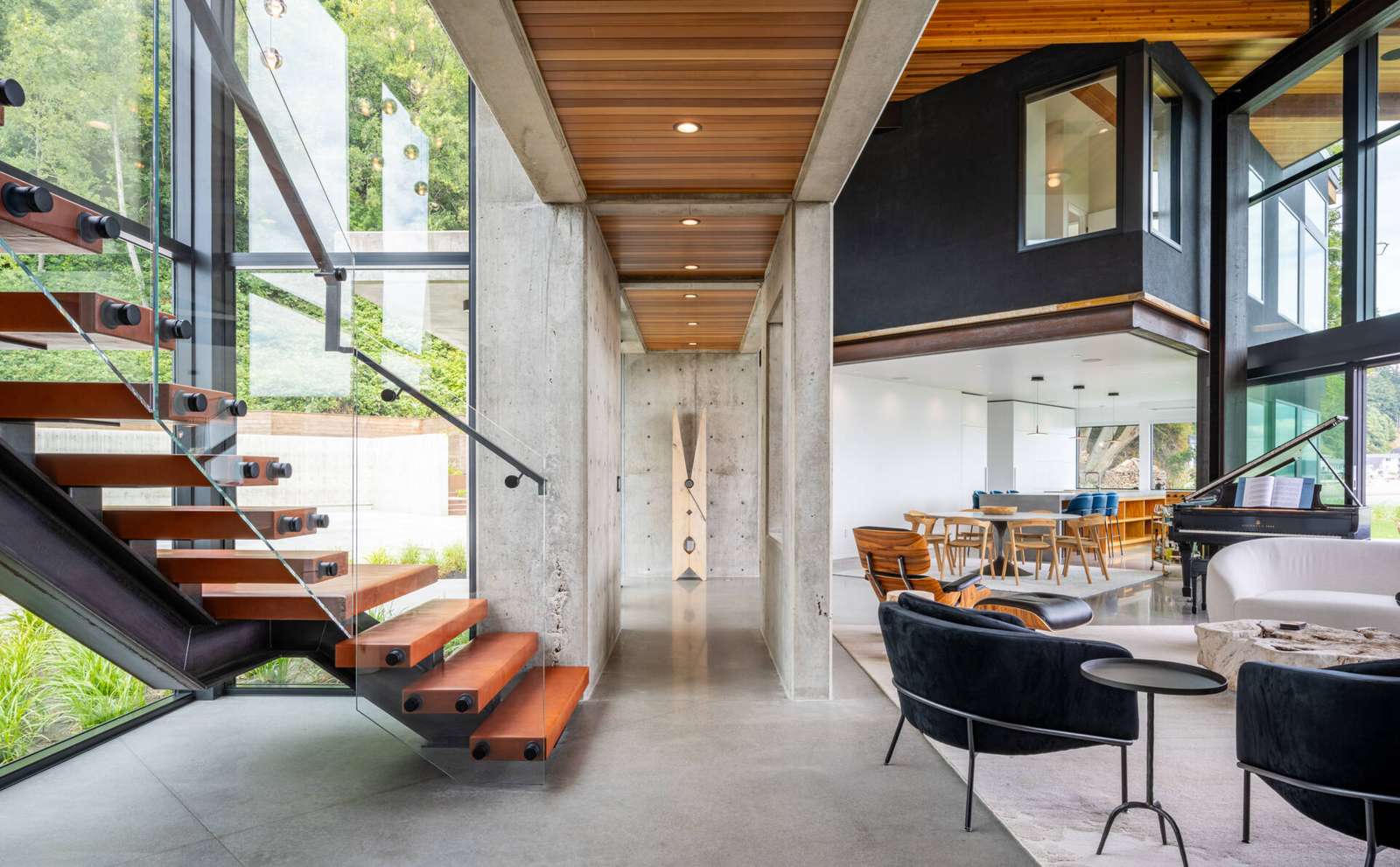 Located off the great room, the staircase is both functional and expressive. Exposed concrete and steel structure are paired with leather treads chosen by the clients, and a large light fixture adds a personal design gesture within the otherwise restrained interior.