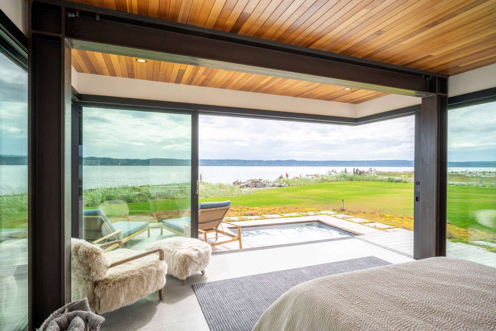 The primary suite is located in the northern wing of the house and has sliding glass walls that open to the terrace where a spa can be found.