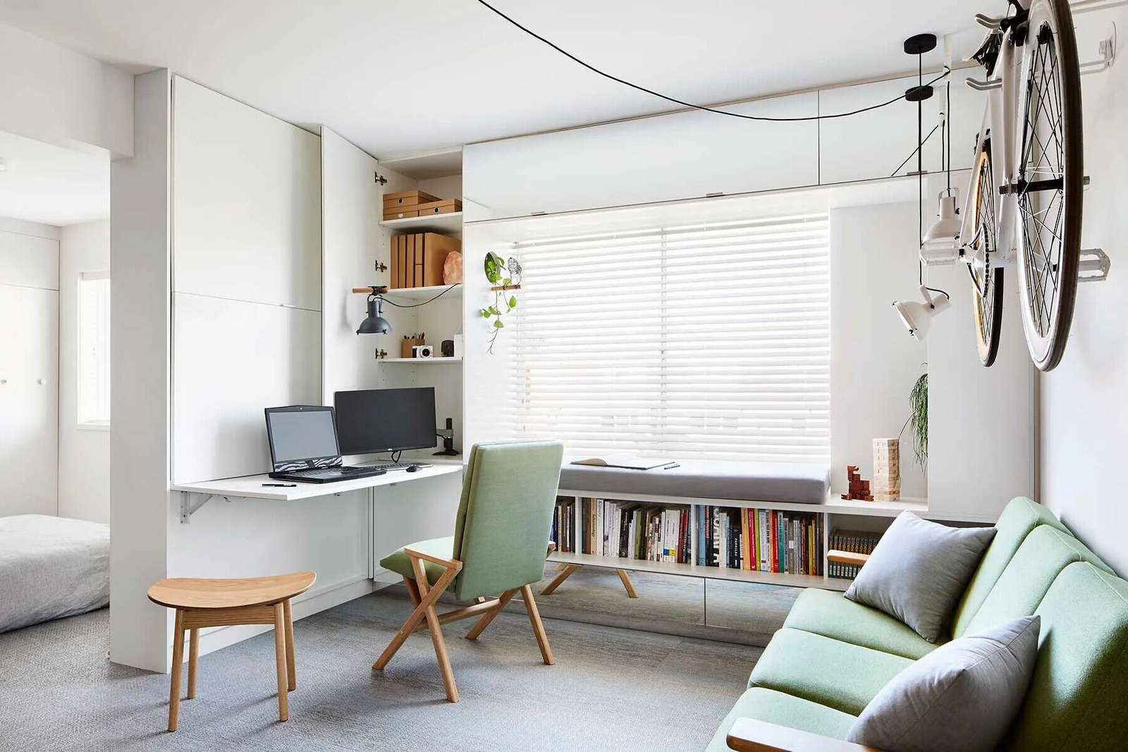 Hidden behind cabinetry, this living room doubles as a home office, allowing work tools to disappear completely when not in use.