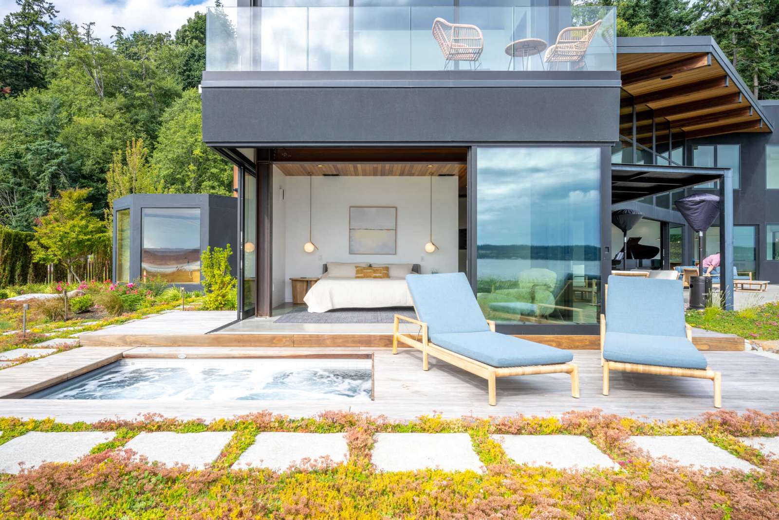 The primary suite is located in the northern wing of the house and has sliding glass walls that open to the terrace where a spa can be found.