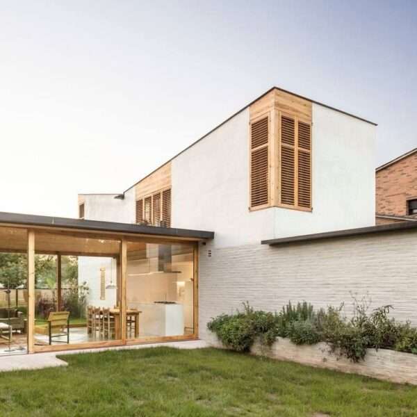 This Spanish family home is shaped by two contrasting volumes, a slender vertical block for privacy and a glass-lined entertaining area that opens fully to the garden.