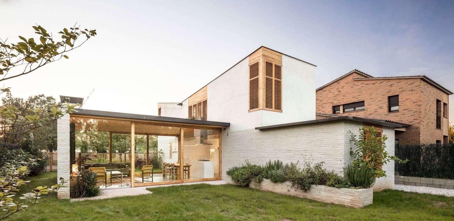 This Spanish family home is shaped by two contrasting volumes, a slender vertical block for privacy and a glass-lined entertaining area that opens fully to the garden.