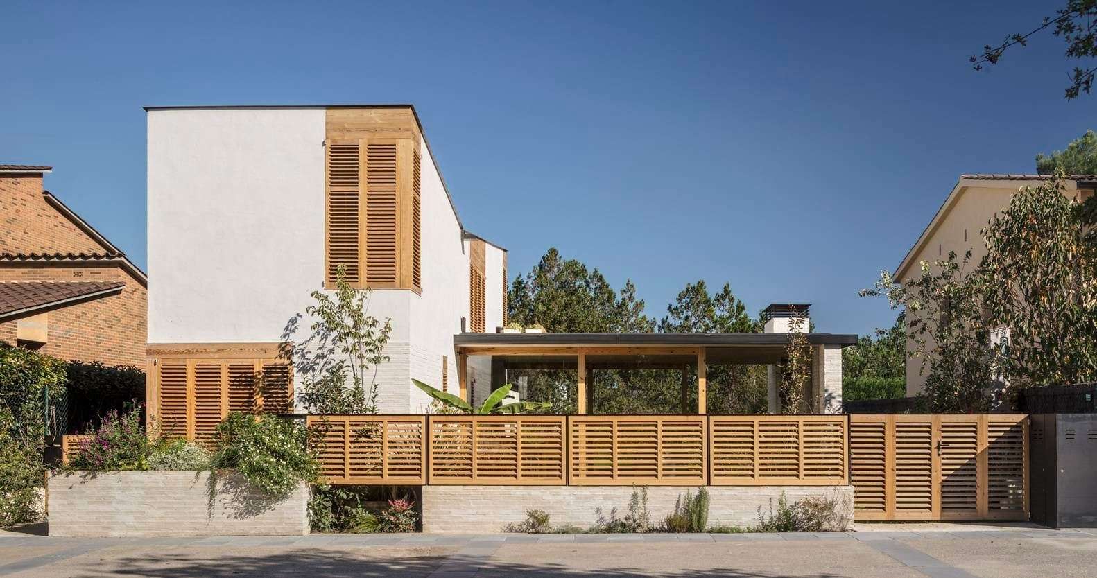 This Spanish family home is shaped by two contrasting volumes, a slender vertical block for privacy and a glass-lined entertaining area that opens fully to the garden.