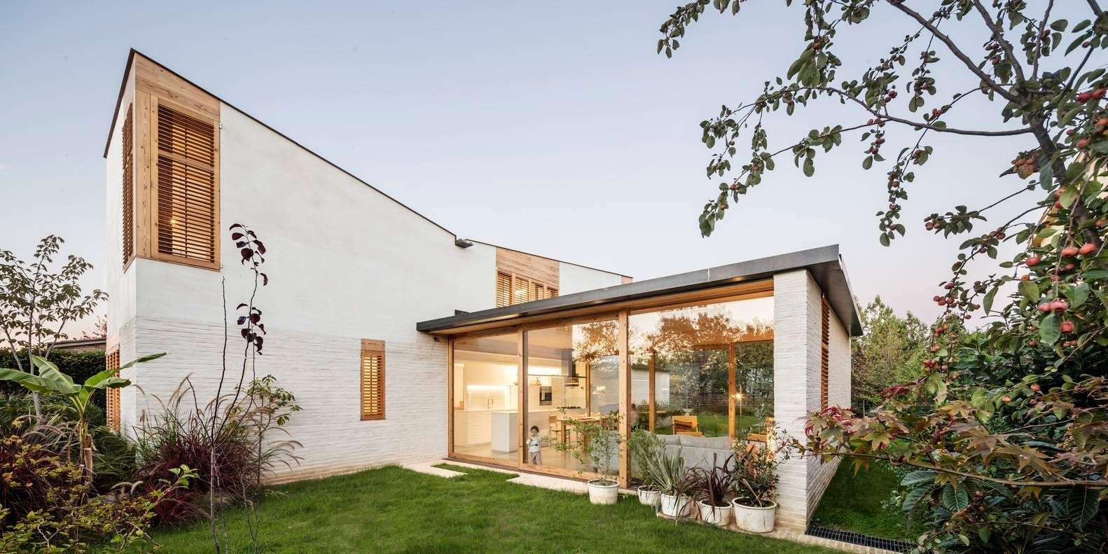 A transparent horizontal volume forms the heart of the home, with sliding glass walls opening to the garden on both sides.