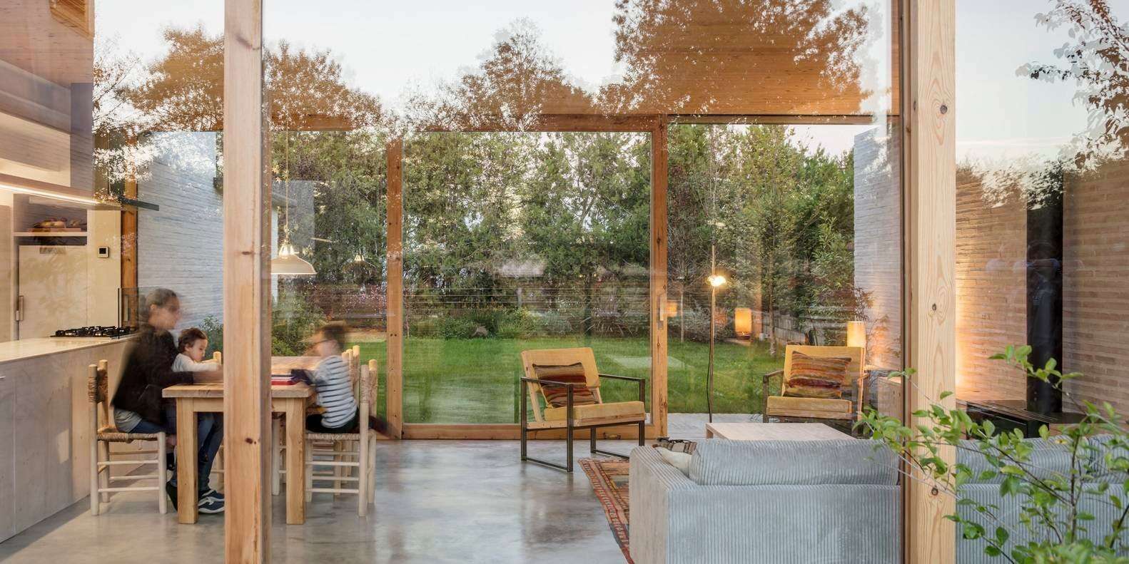 A transparent horizontal volume forms the heart of the home, with sliding glass walls opening to the garden on both sides.