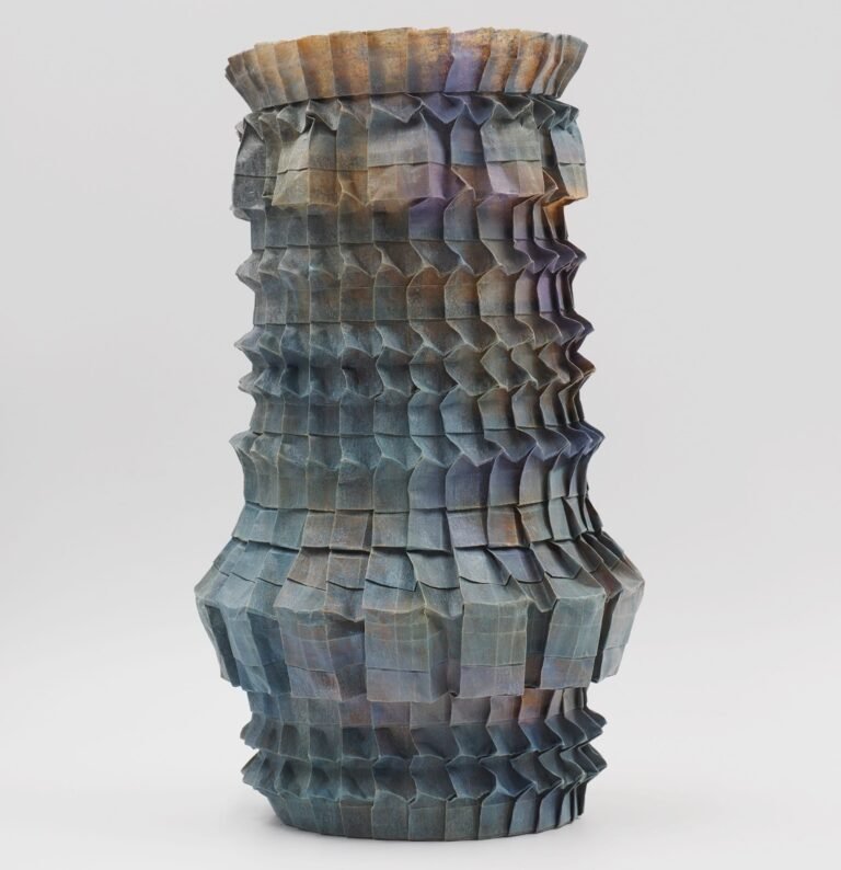 An origami paper vase with a nuanced gradient of grays and pinks