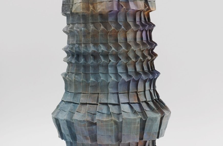 An origami paper vase with a nuanced gradient of grays and pinks