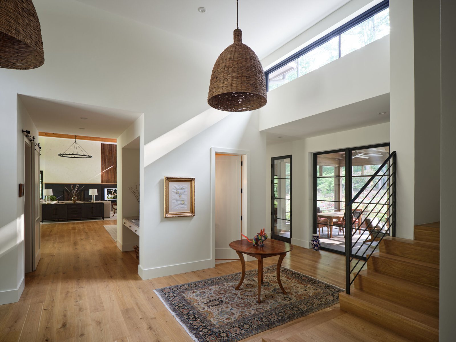 The entry opens into a bright interior with natural materials and long sightlines stretching through the home.