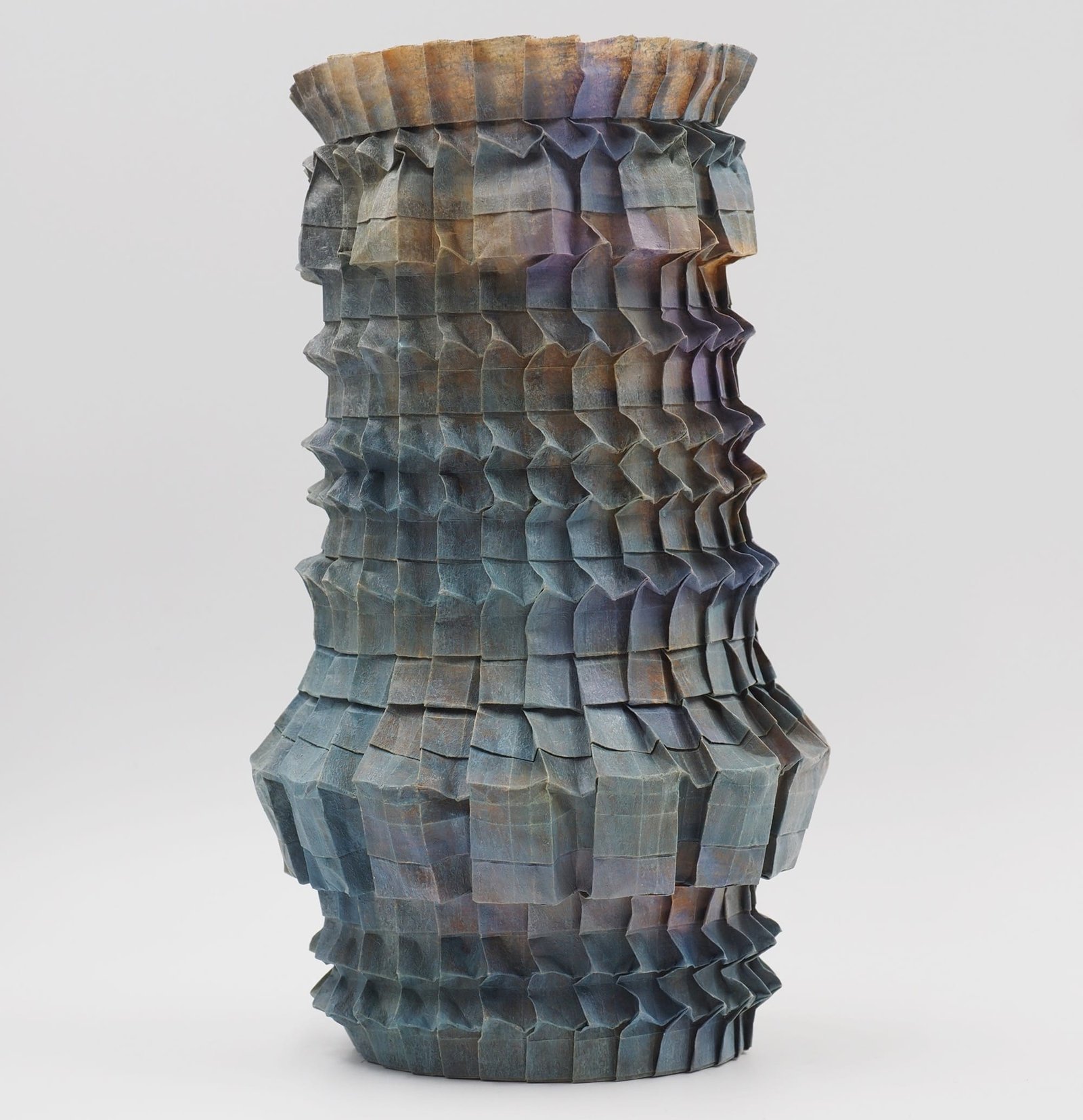 An origami paper vase with a nuanced gradient of grays and pinks