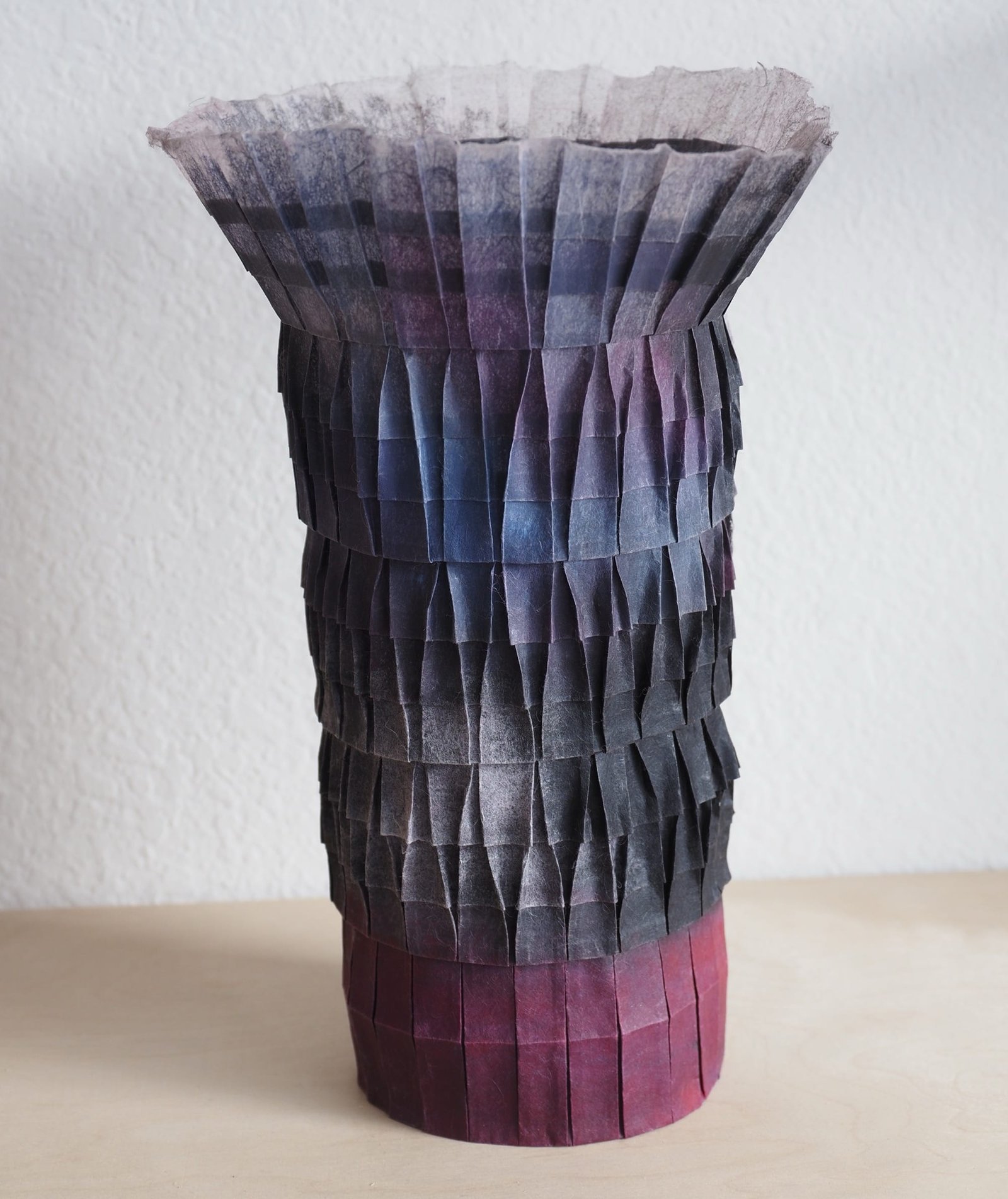 An origami paper vase with a blue-magenta gradient