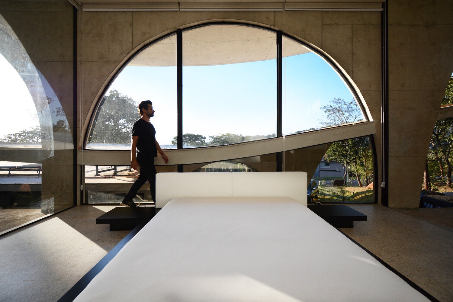 Bedrooms are shaped by large arches that bring in natural light and frame views of private gardens.