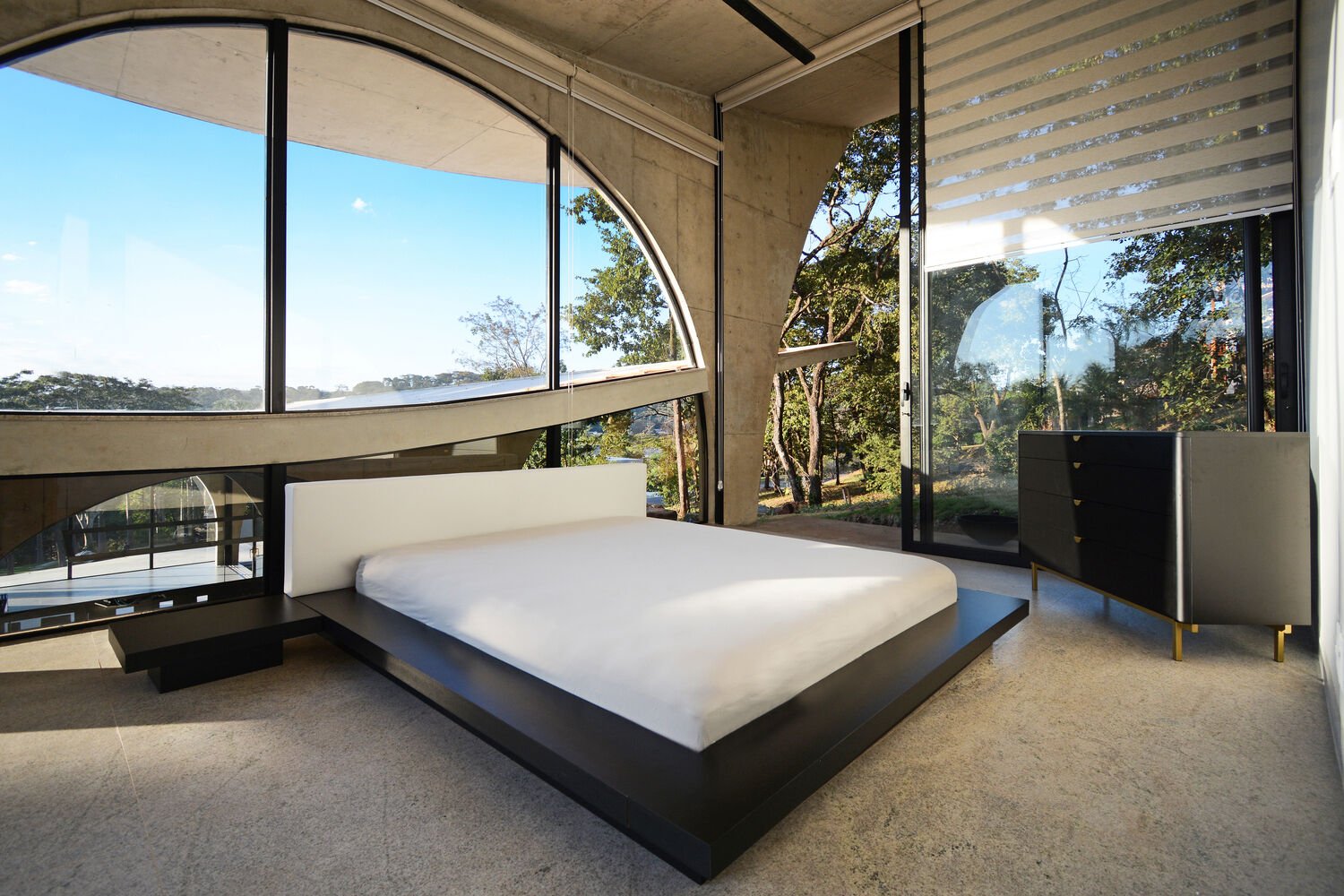 Bedrooms are shaped by large arches that bring in natural light and frame views of private gardens.