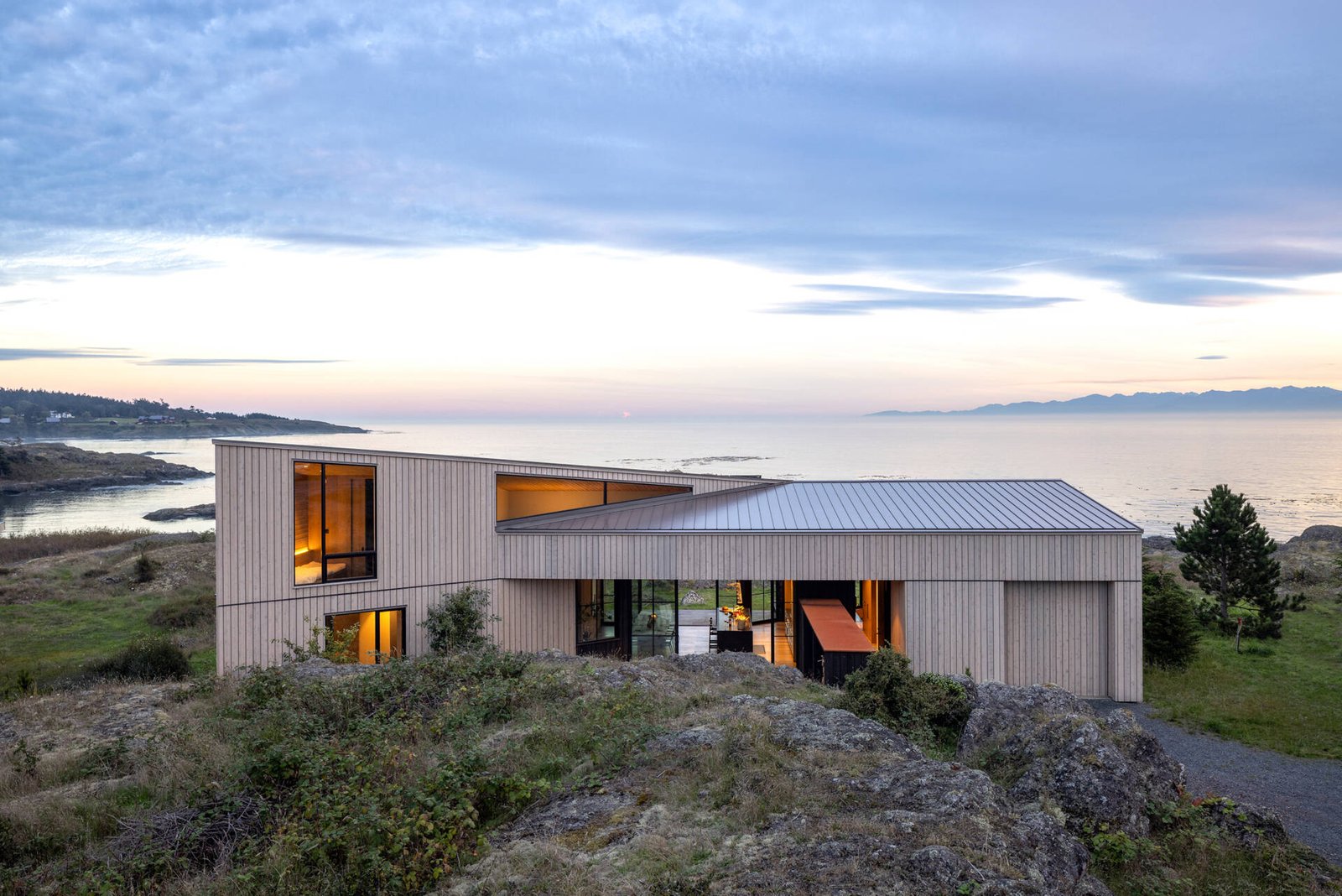Cedar cladding and weathered finishes allow this home to blend into the rugged coastline.