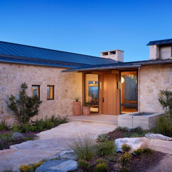 Limestone walls and a metal roof create a bold and cohesive material palette across this Texas ranch home.