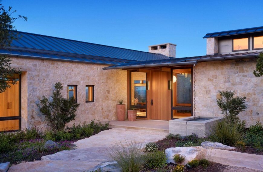 Limestone walls and a metal roof create a bold and cohesive material palette across this Texas ranch home.