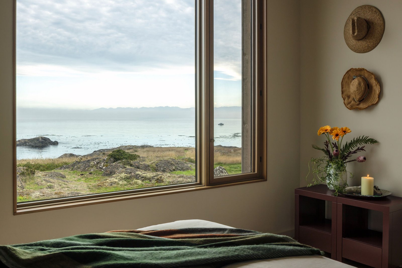 Located on the ground floor, the primary bedroom offers privacy and easy access to the main living areas. Like the rest of the home, it keeps materials simple and tones muted, letting the natural surroundings take the lead.