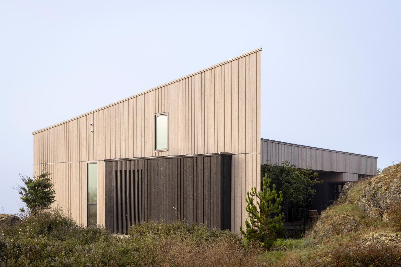 Cedar cladding and weathered finishes allow this home to blend into the rugged coastline.