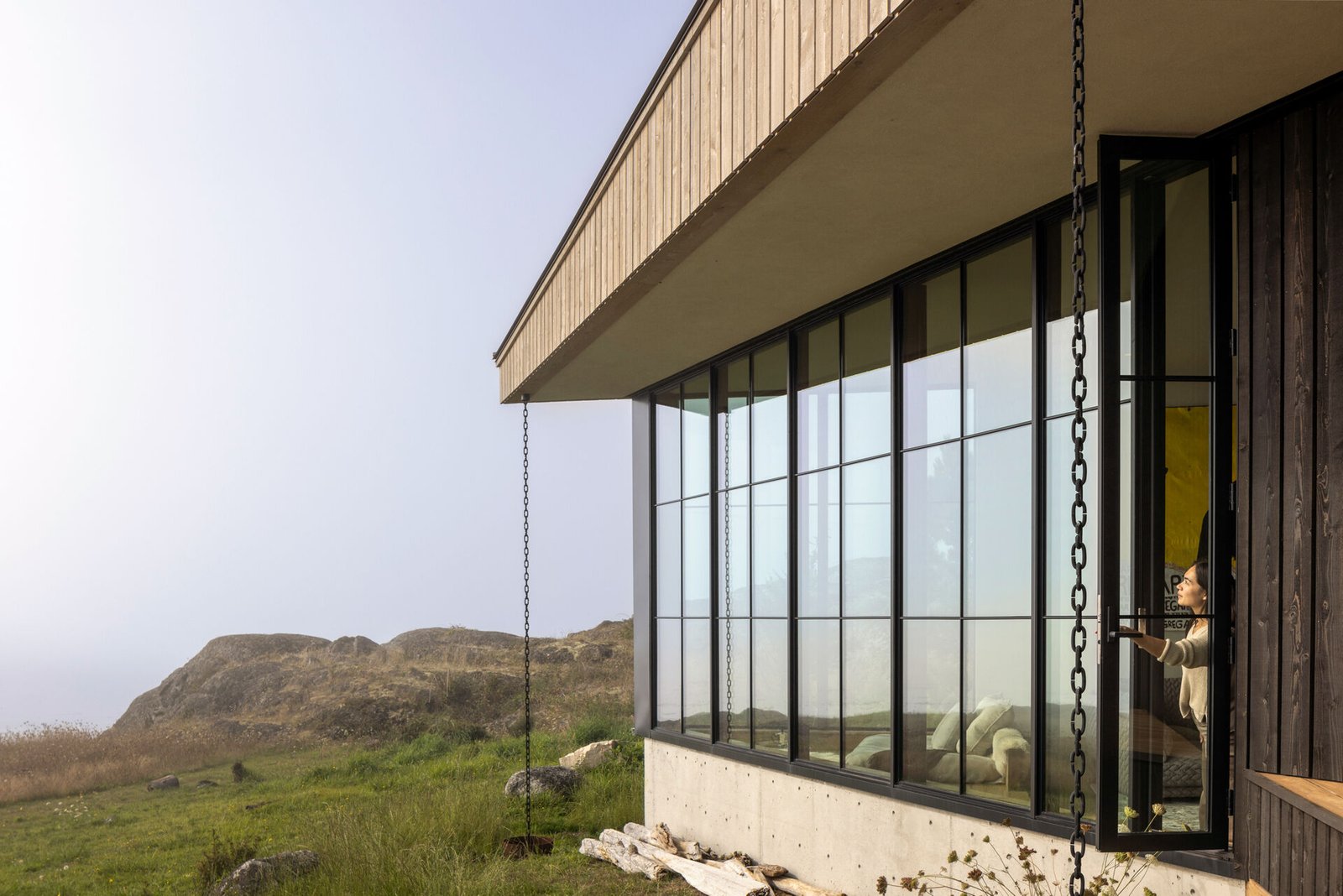 Cedar cladding and weathered finishes allow this home to blend into the rugged coastline.