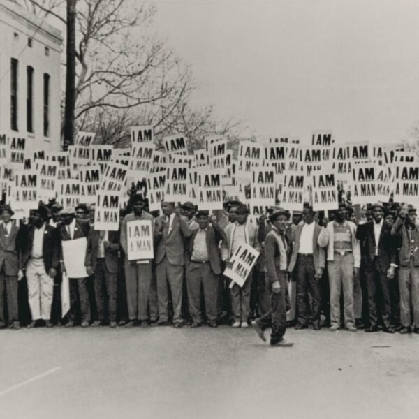 a black and white photo of a crowd picketing