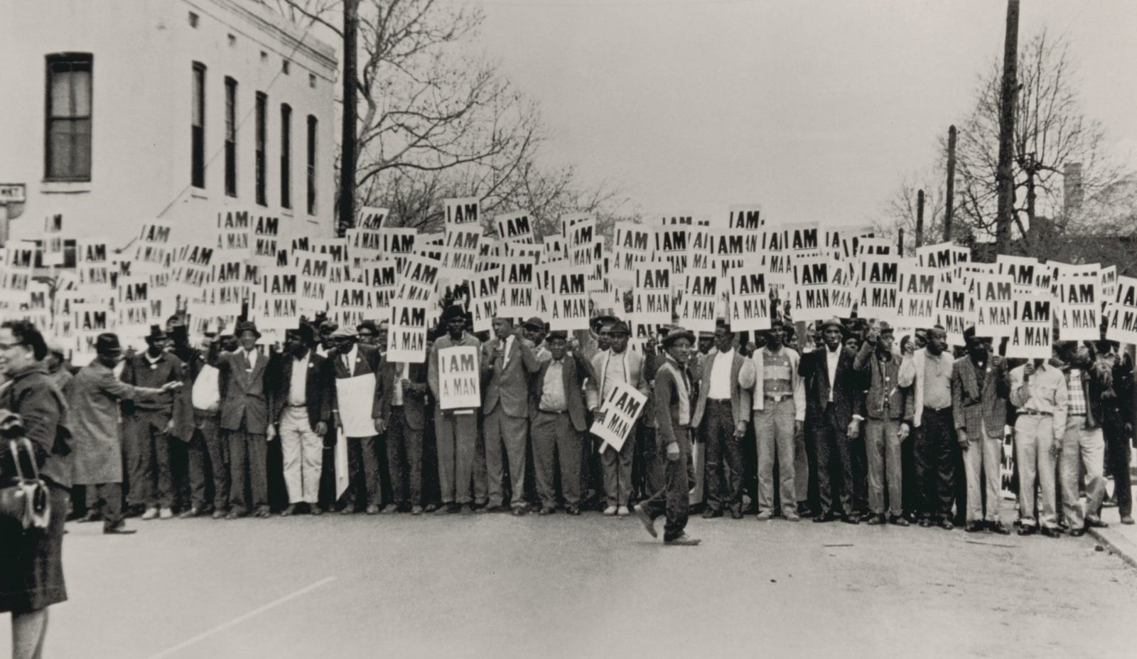 a black and white photo of a crowd picketing