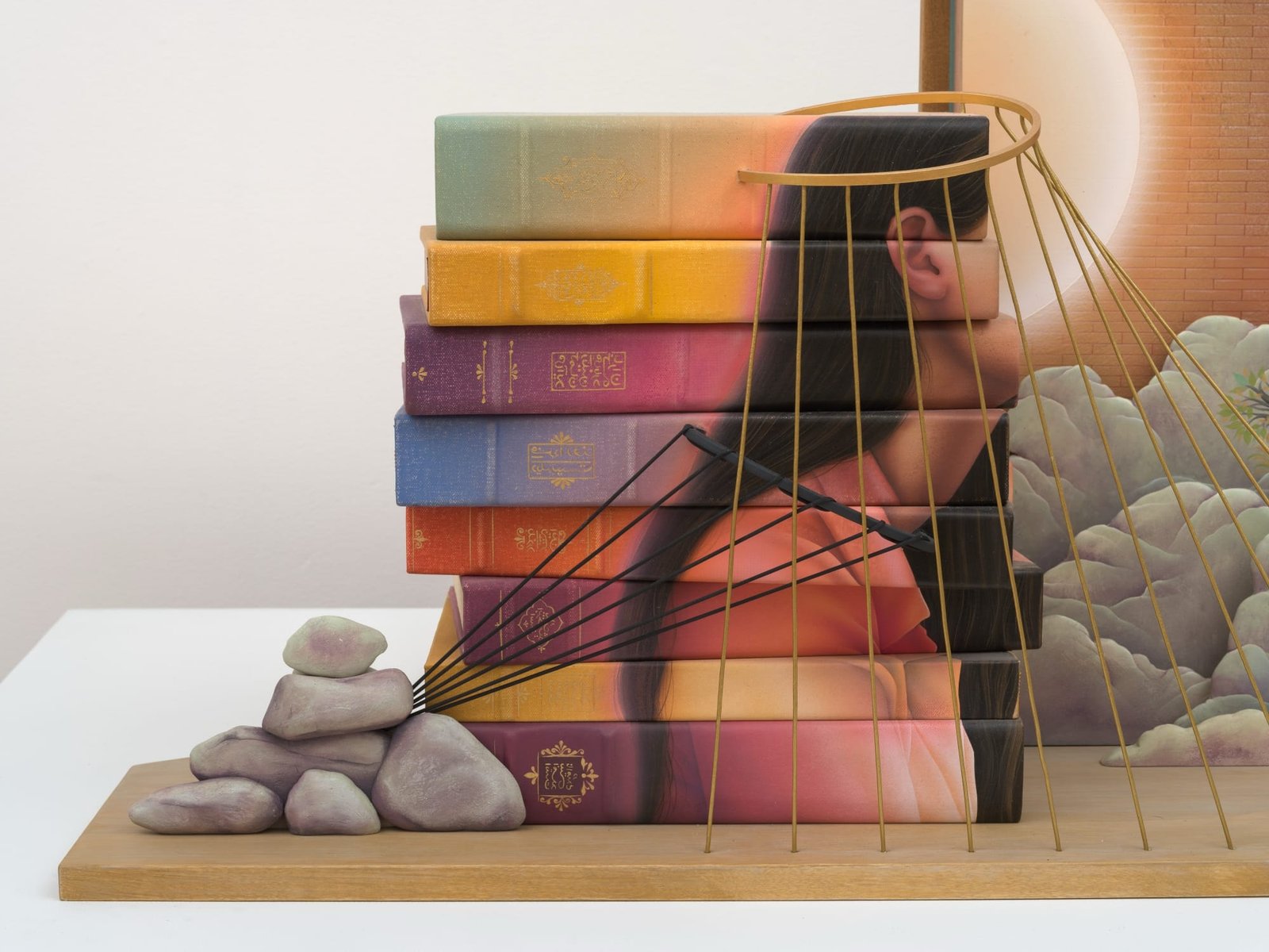 a woman's silhouette bound with gold cord on a stack of books