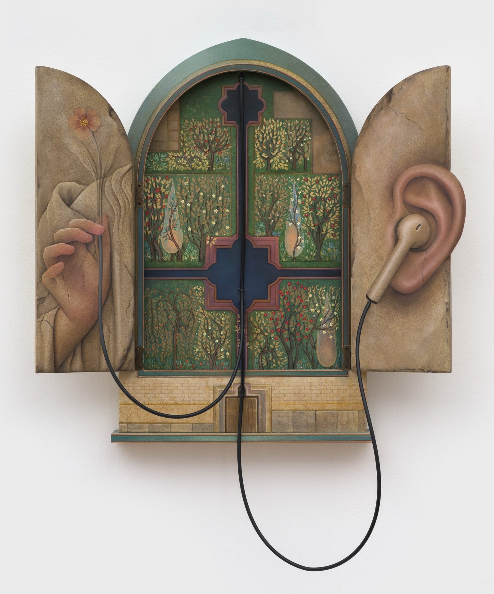 an architectural sculpture of a Persian window with shutters opened to show a hand and a headphone cord running to an ear on the right side