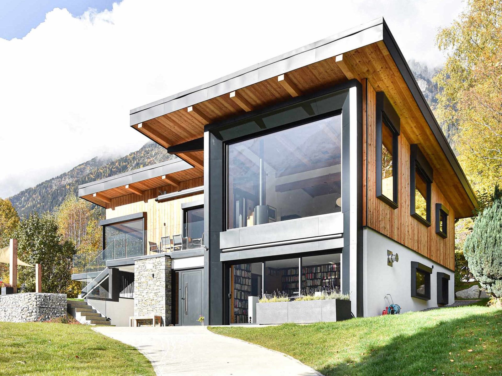 This Chamonix renovation features a massive black framed picture window that perfectly captures mountain views while flooding the home with natural light.