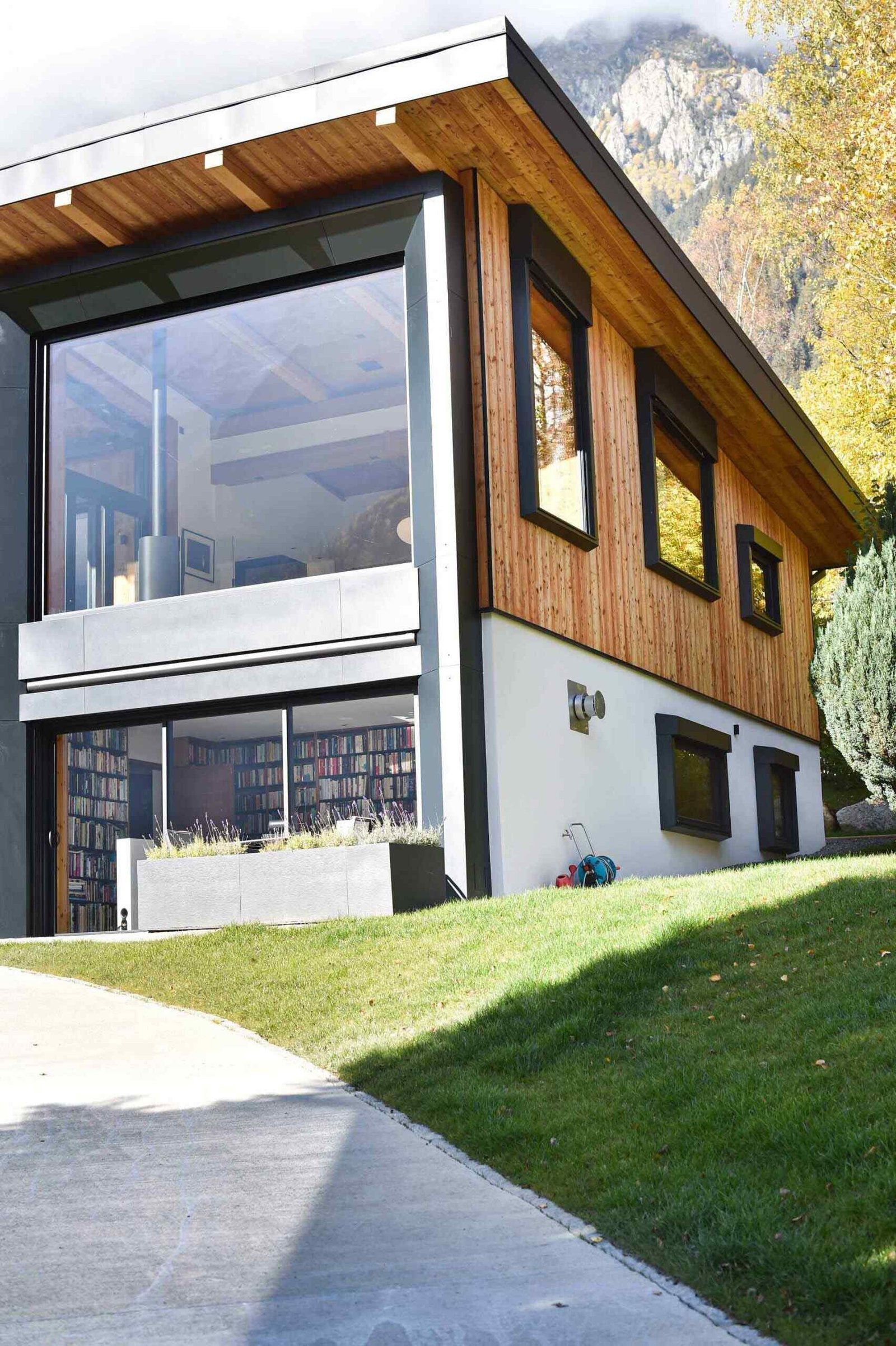 This Chamonix renovation features a massive black framed picture window that perfectly captures mountain views while flooding the home with natural light.